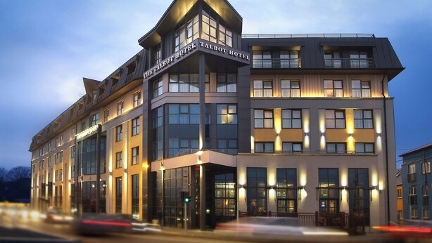 A modern hotel with a prominent corner entrance, large windows, and a well-lit facade. - Talbot Hotel Wexford (Wexford)