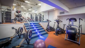 A gym with exercise equipment, a stairway, and a mirrored wall. - Talbot Hotel Wexford (Wexford)