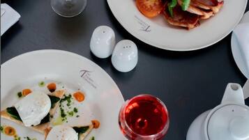Ein Frühstückstisch mit Speisen, einem Glas Orangensaft und einer Teekanne.