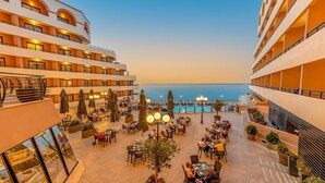 A hotel with multiple floors, outdoor dining areas, and a pool. - Radisson Blu Resort, Malta St. Julian's (St. Julian's)