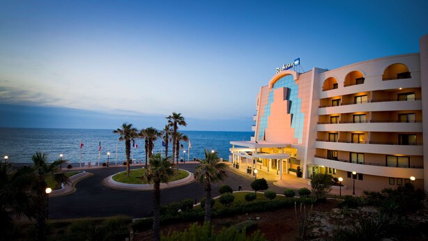 A hotel with a modern design, featuring multiple balconies and a view of the sea. - Radisson Blu Resort, Malta St. Julian's (St. Julian's)