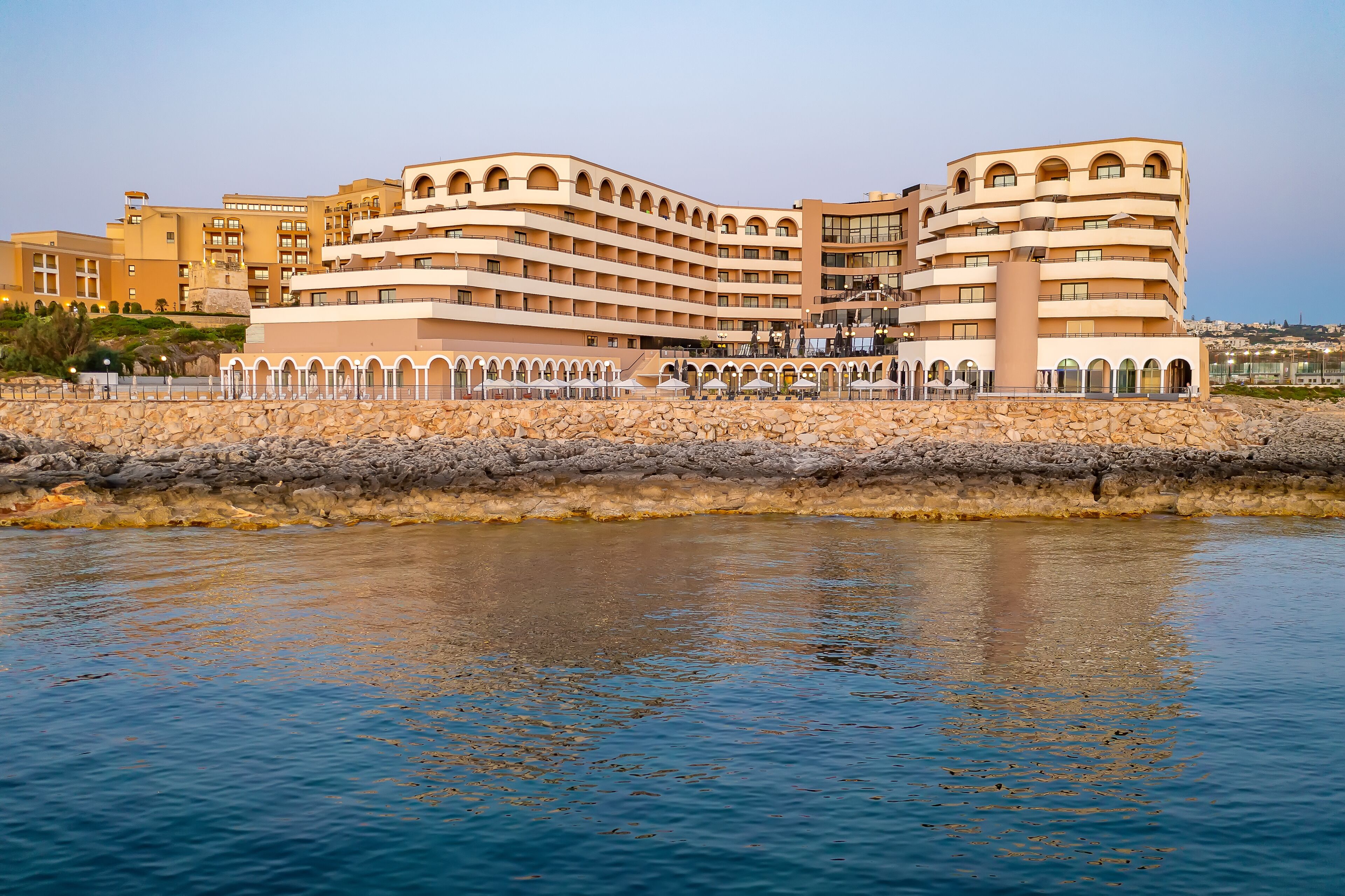 Un grand hôtel à plusieurs étages, doté d’une façade incurvée, de nombreux balcons et situé en bord de mer.