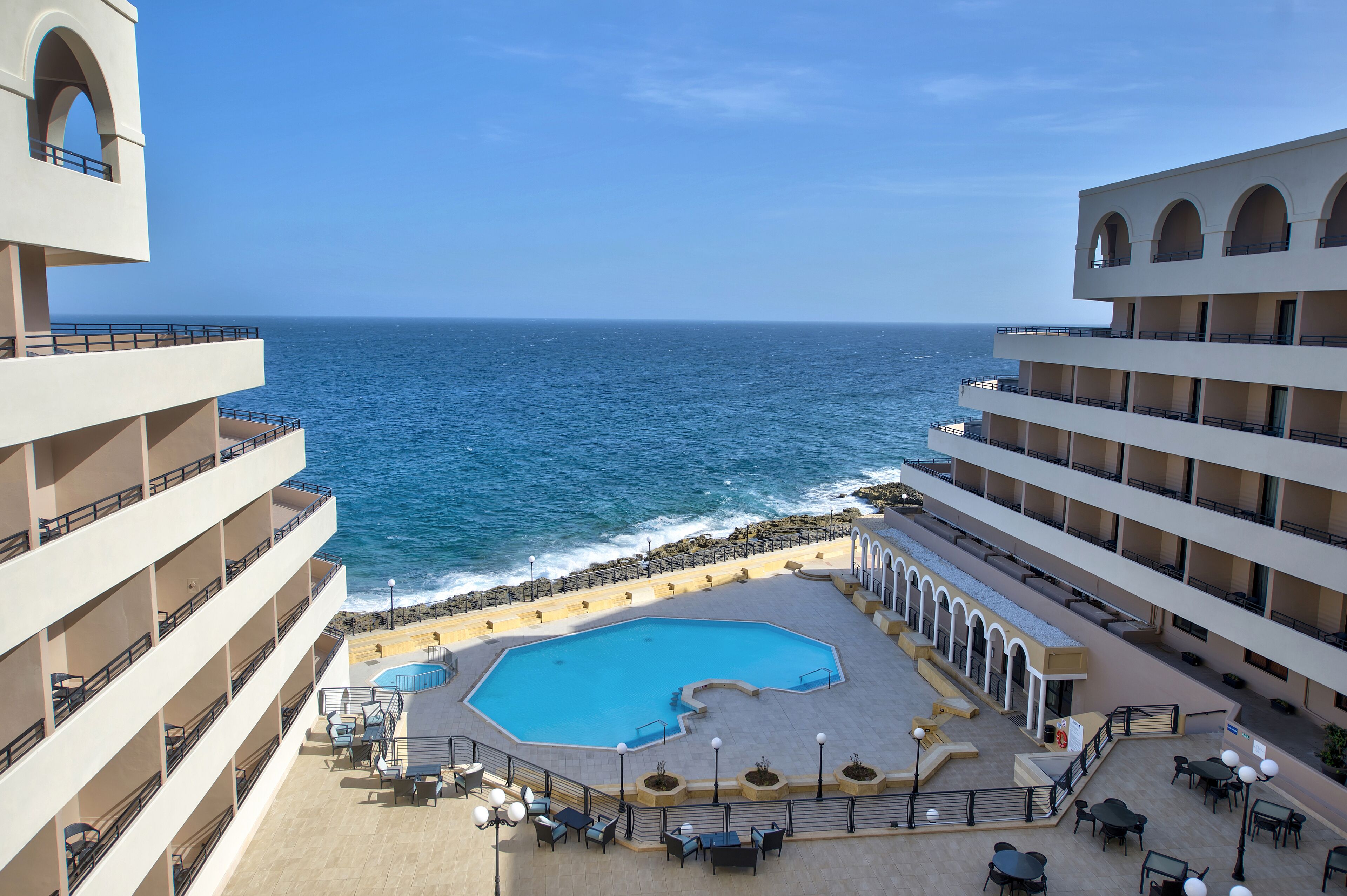 Un hôtel doté d’une piscine, d’un espace extérieur aménagé et offrant une vue sur l’océan.