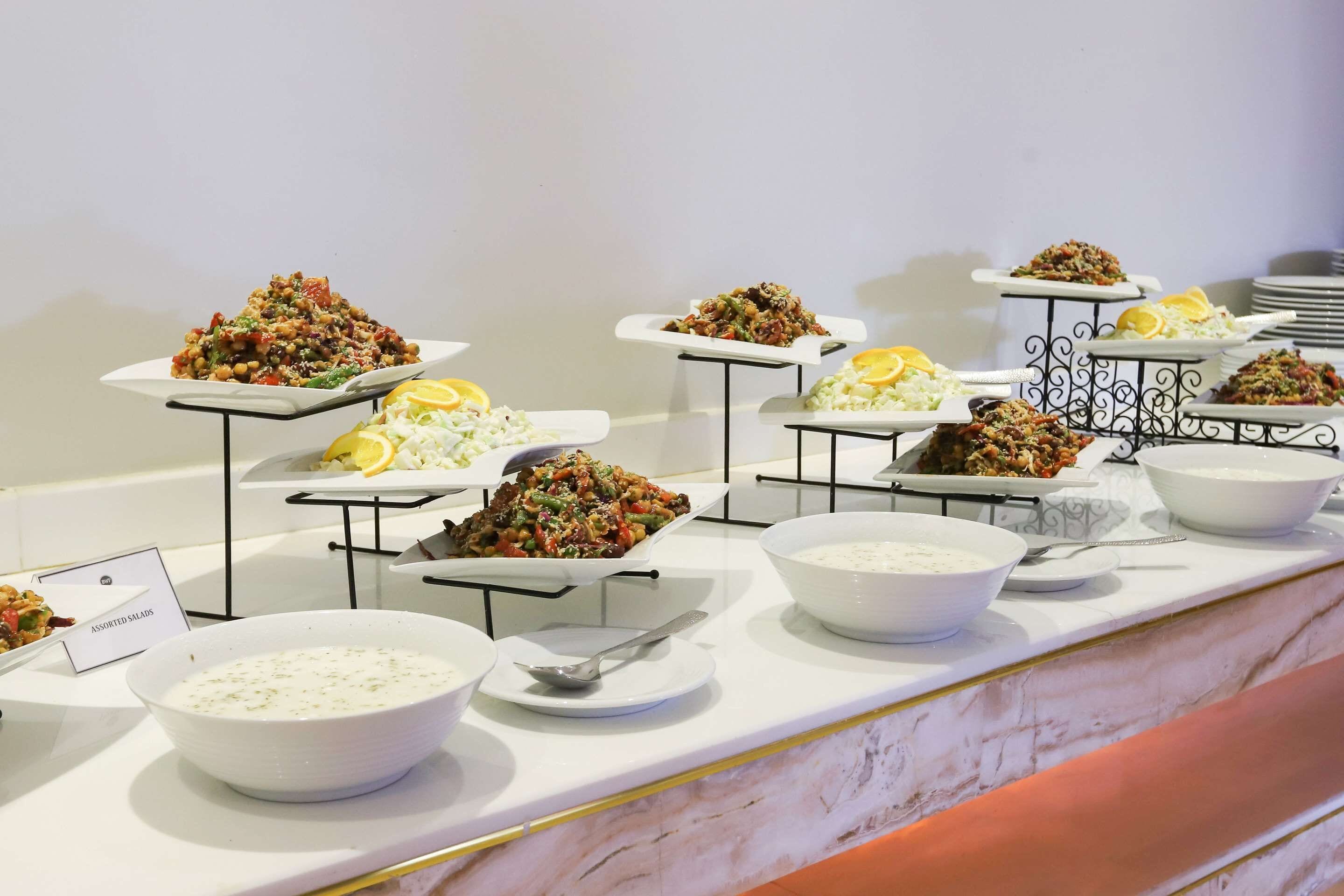 A buffet with various dishes including salads, rice, and a bowl of soup.