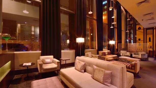 Una hall moderna di un hotel con un divano, poltrone e un tavolino.