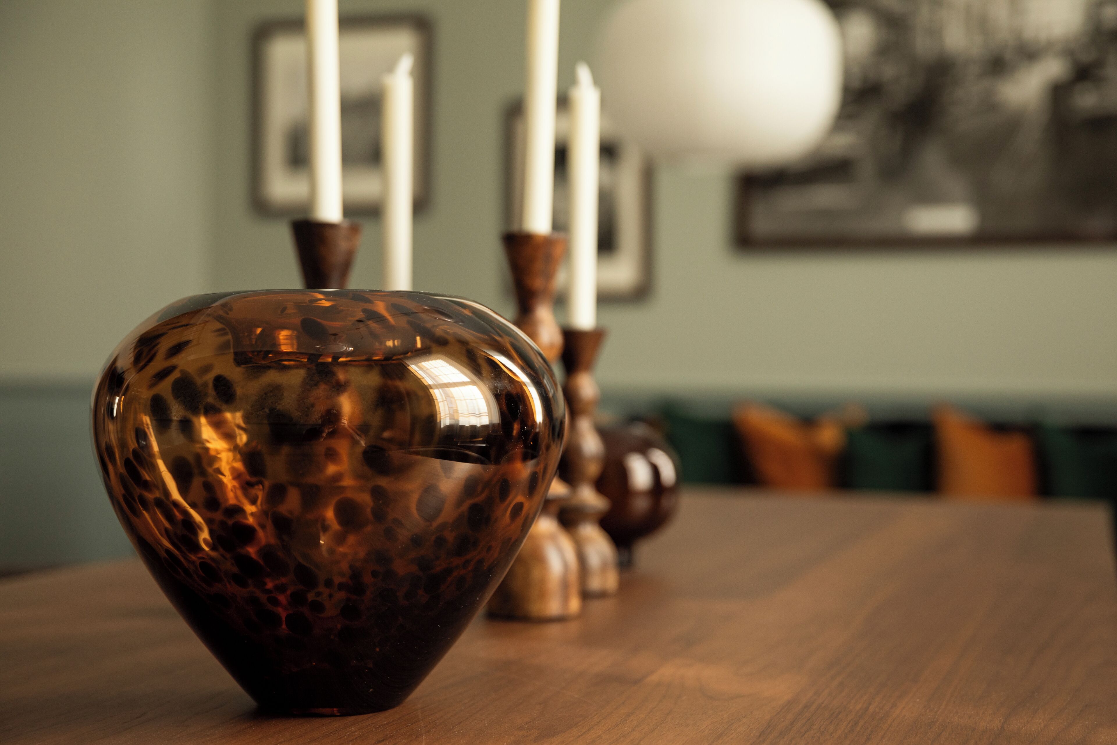 A wooden table with a decorative vase in the foreground.