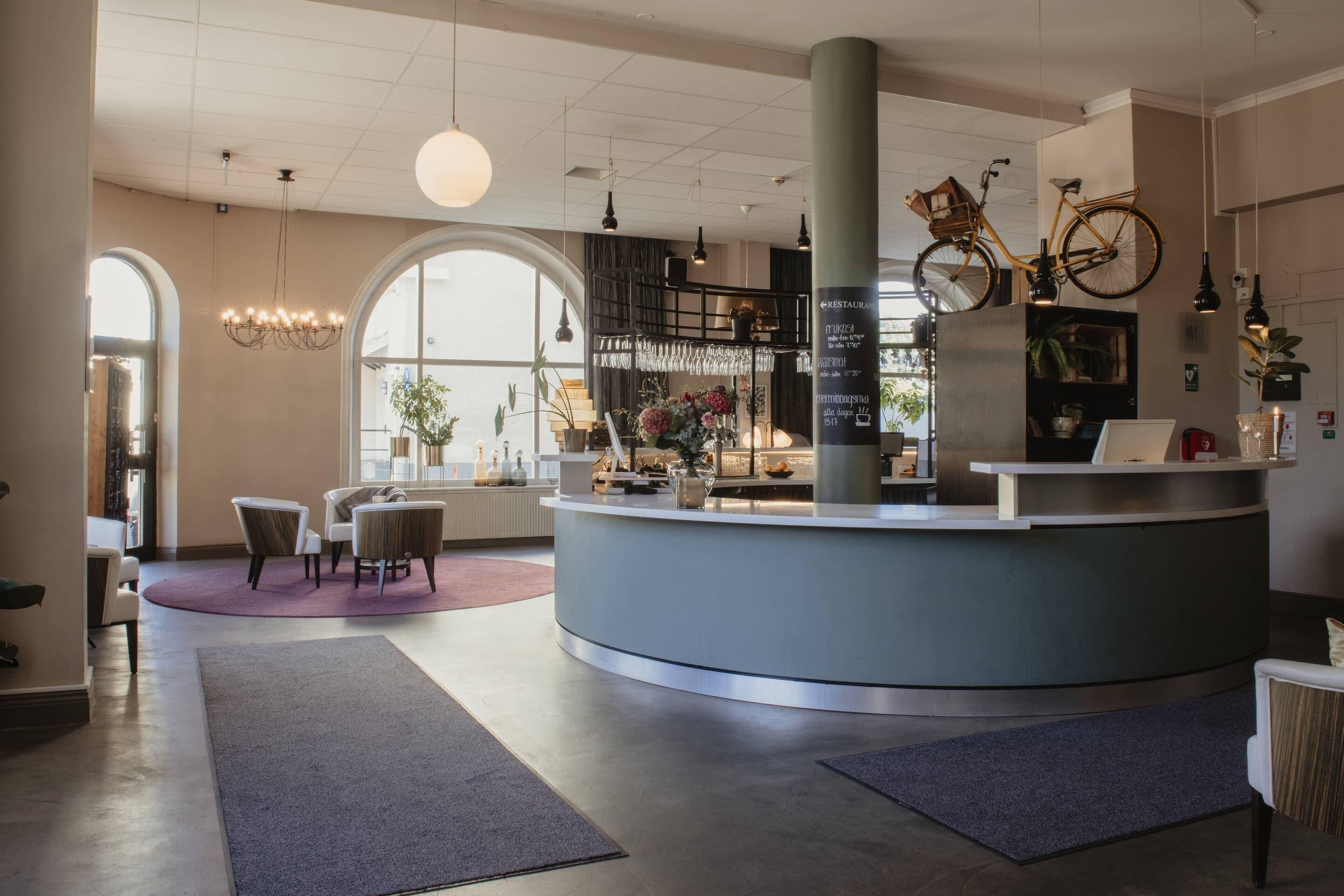 A modern reception area with a curved counter, seating, and a bicycle mounted on a pillar.