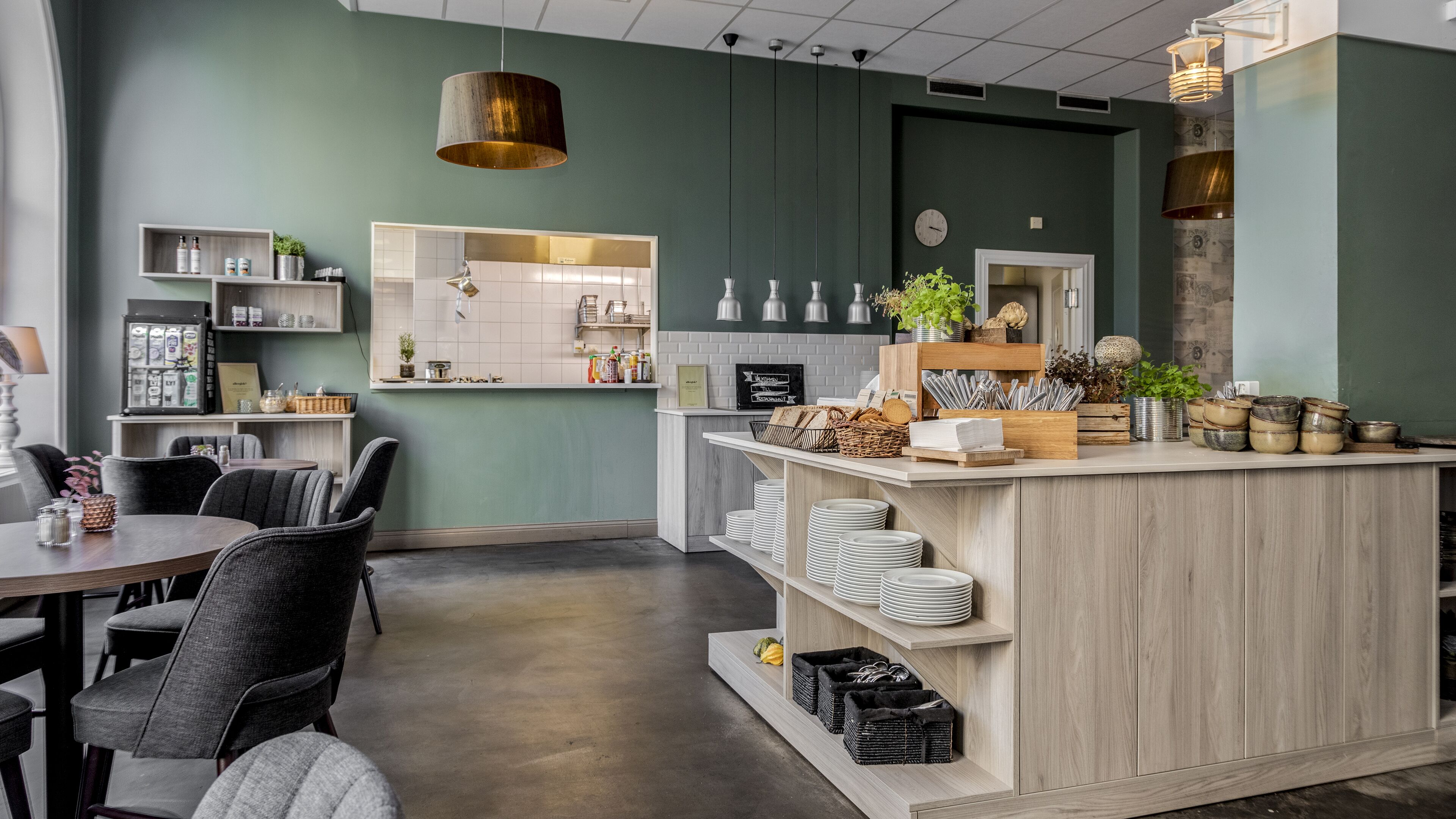 Una cocina moderna con una isla central, armarios de madera y un comedor con sillas.
