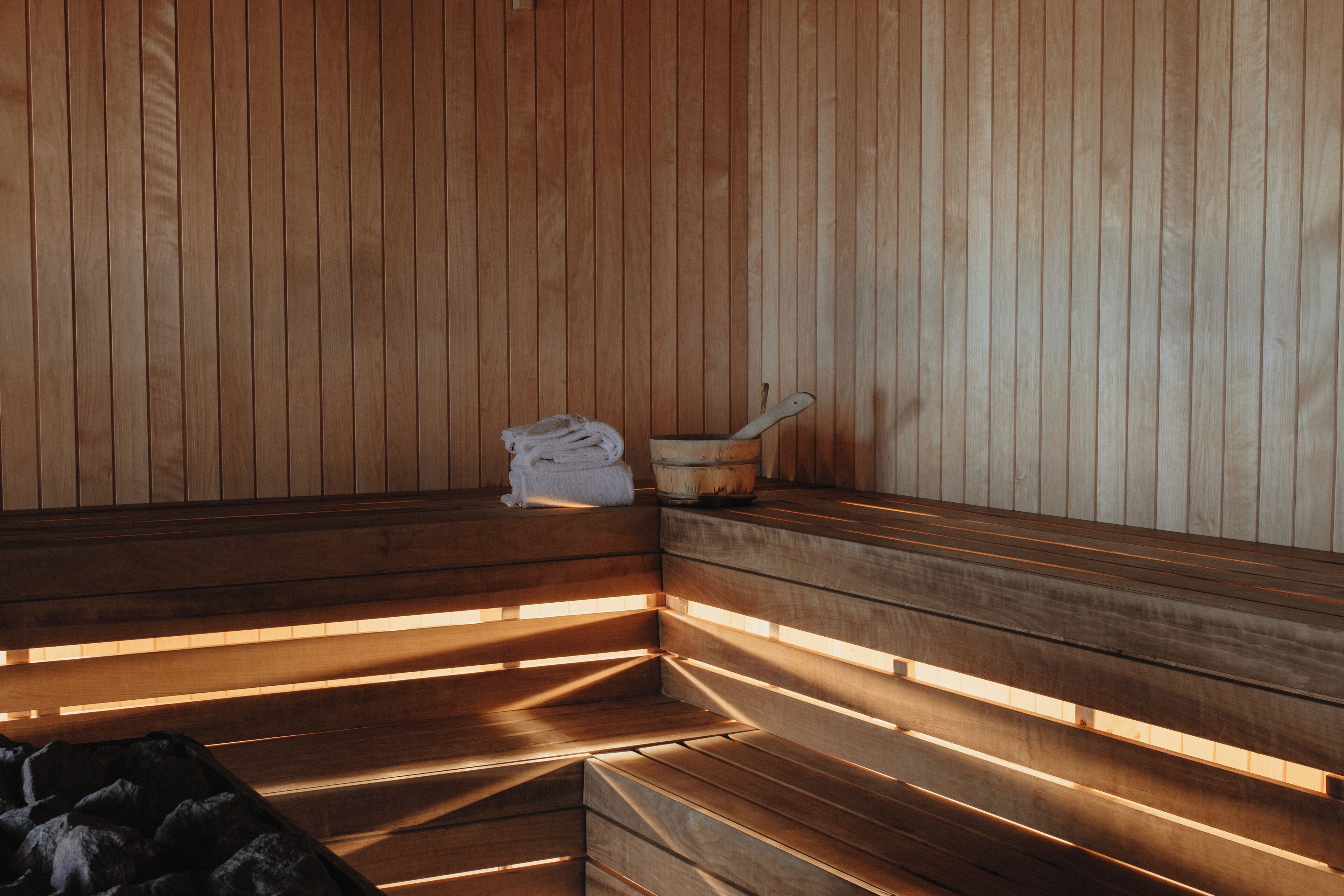 Een sauna met houten banken en een handdoek op een van de zitplaatsen.
