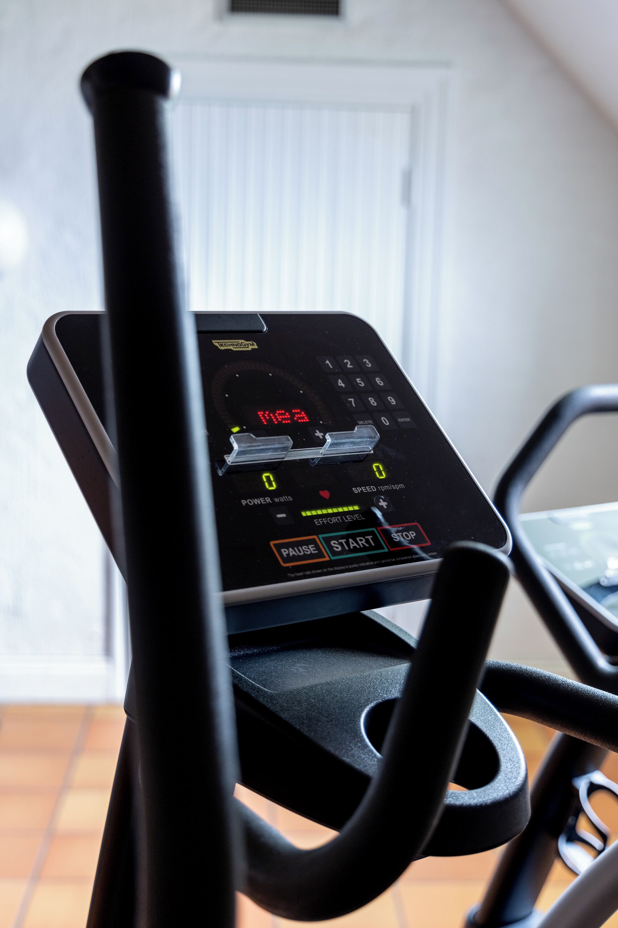 A stationary exercise bike with a digital display and control panel.