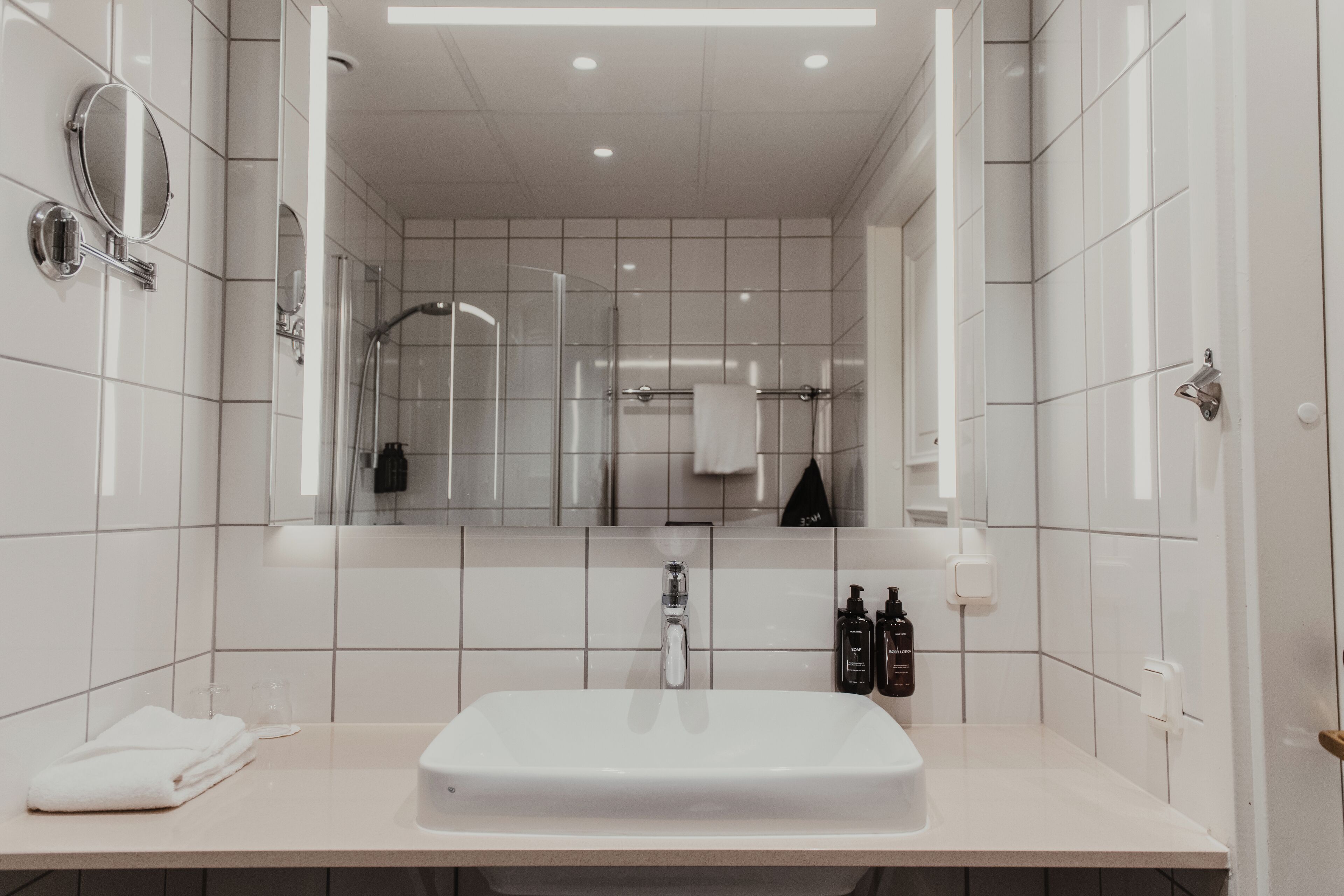 Une salle de bain moderne avec un lavabo blanc, un miroir et une serviette.