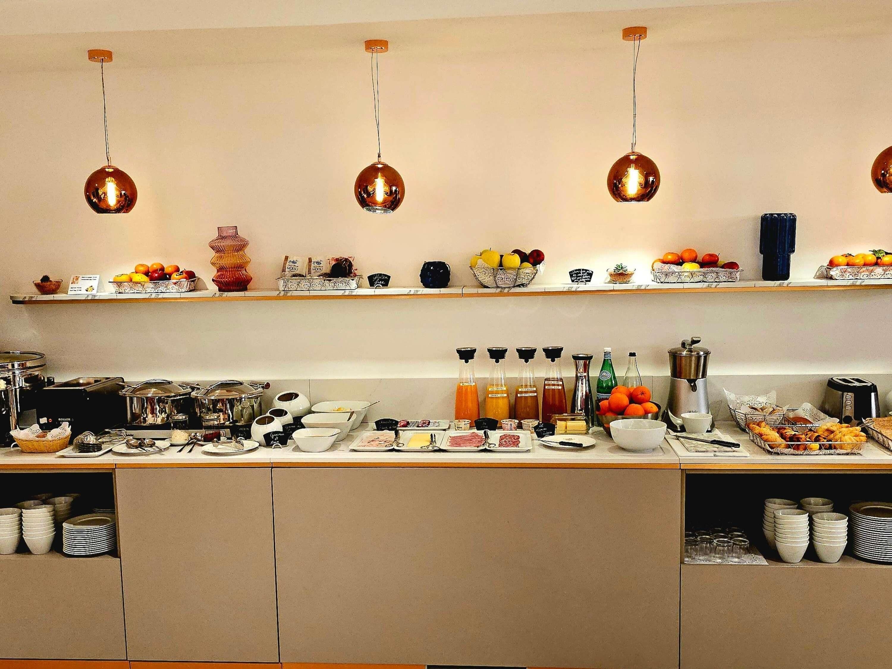 Un bufé de desayuno con diversos alimentos, bebidas y aderezos.
