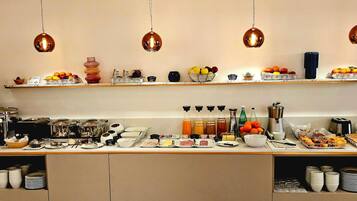 Un bufé de desayuno con diversos alimentos, bebidas y aderezos.