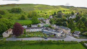 A village with traditional stone buildings, a central square, and a prominent church. - Rising Sun Hotel by Greene King Inns (Cheltenham)