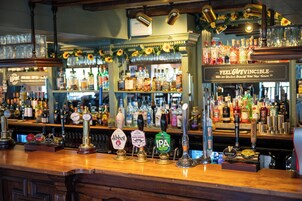 Un bar con múltiples grifos de cerveza, incluyendo marcas como Abbott, Pale Ale e IPA.