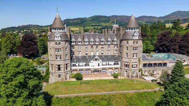 A large, historic building with multiple towers and a central courtyard.