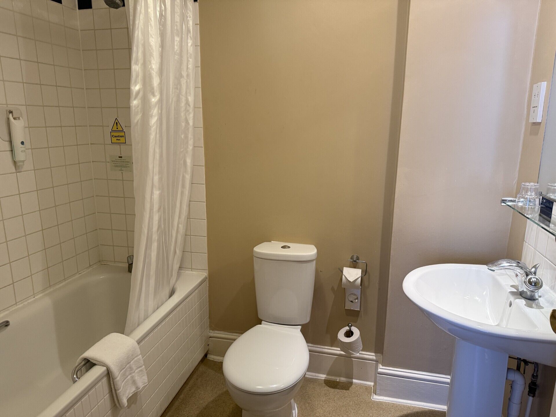 A bathroom with a bathtub, toilet, and sink.