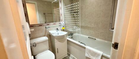 Een moderne badkamer met toilet, wastafel en bad.