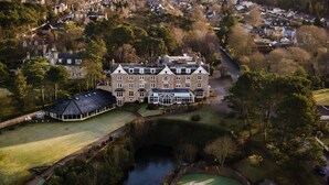 An aerial view of a large estate with a prominent building labeled "GOLF VIEW HOTEL," a tennis court, and a small pond.
