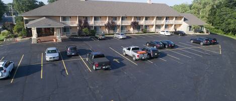 A multi-story motel with a parking lot containing various vehicles.