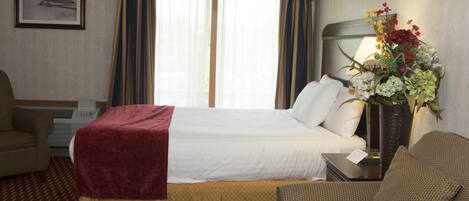 Una habitación de hotel con una cama, un sofá, un escritorio y una silla.