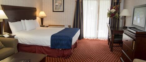 A hotel room with a bed, a desk, a television, and a chair.