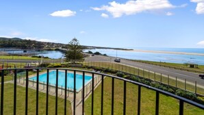 A pool with a clear view of the beach and ocean.