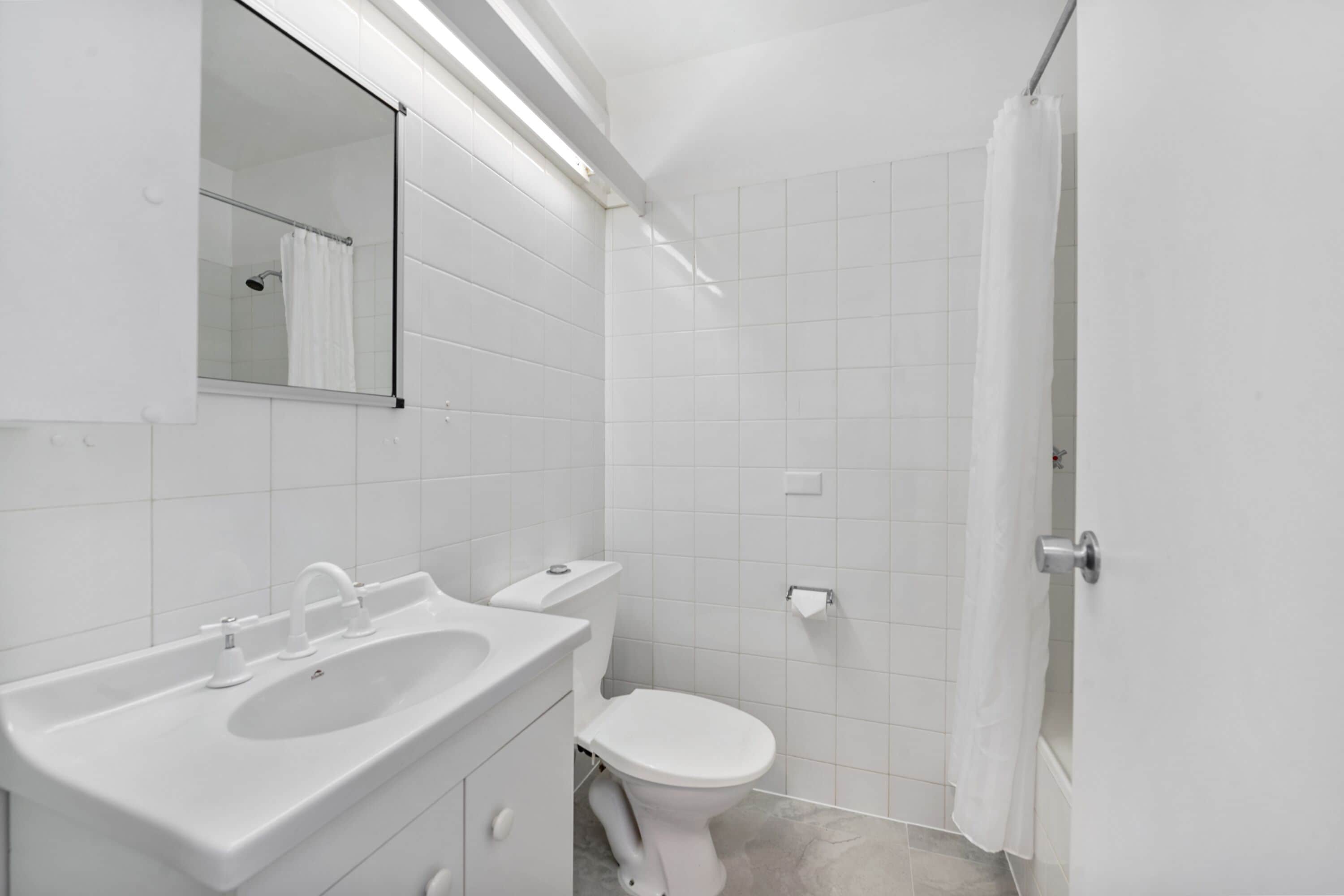 Ein modernes Badezimmer mit Waschbecken, Toilette und Duschvorhang.