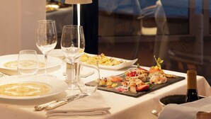A dining table set with plates, glasses, and a bottle of champagne. - Grand Hotel Astoria (Grado)