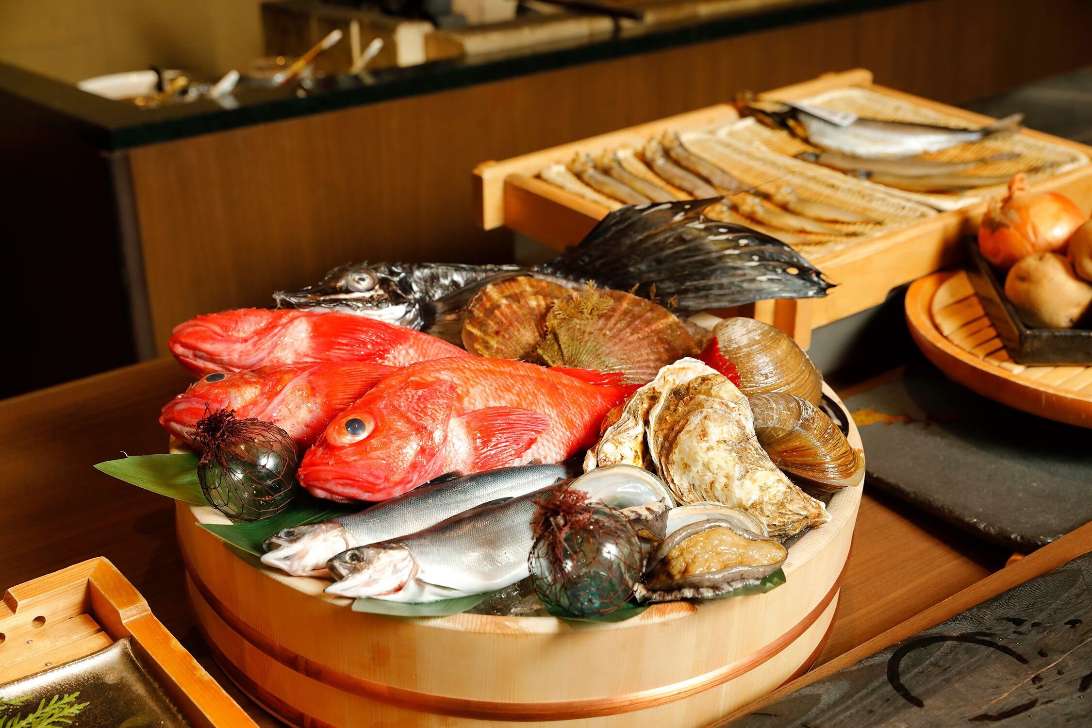 A wooden bowl filled with various seafood including fish, clams, and oysters.
