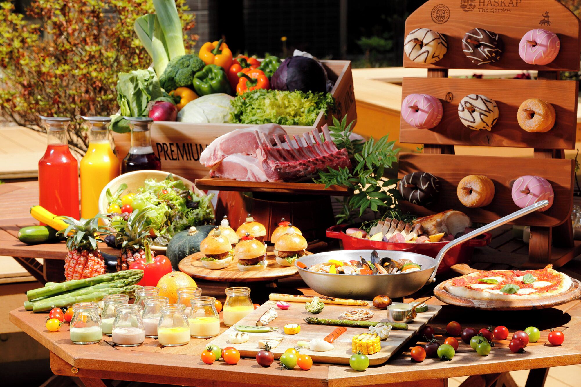 Une table sur laquelle on trouve divers aliments, notamment des légumes, des fruits et une pizza.