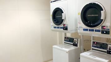 A laundry area with three washing machines, two stacked on top of each other and one below.