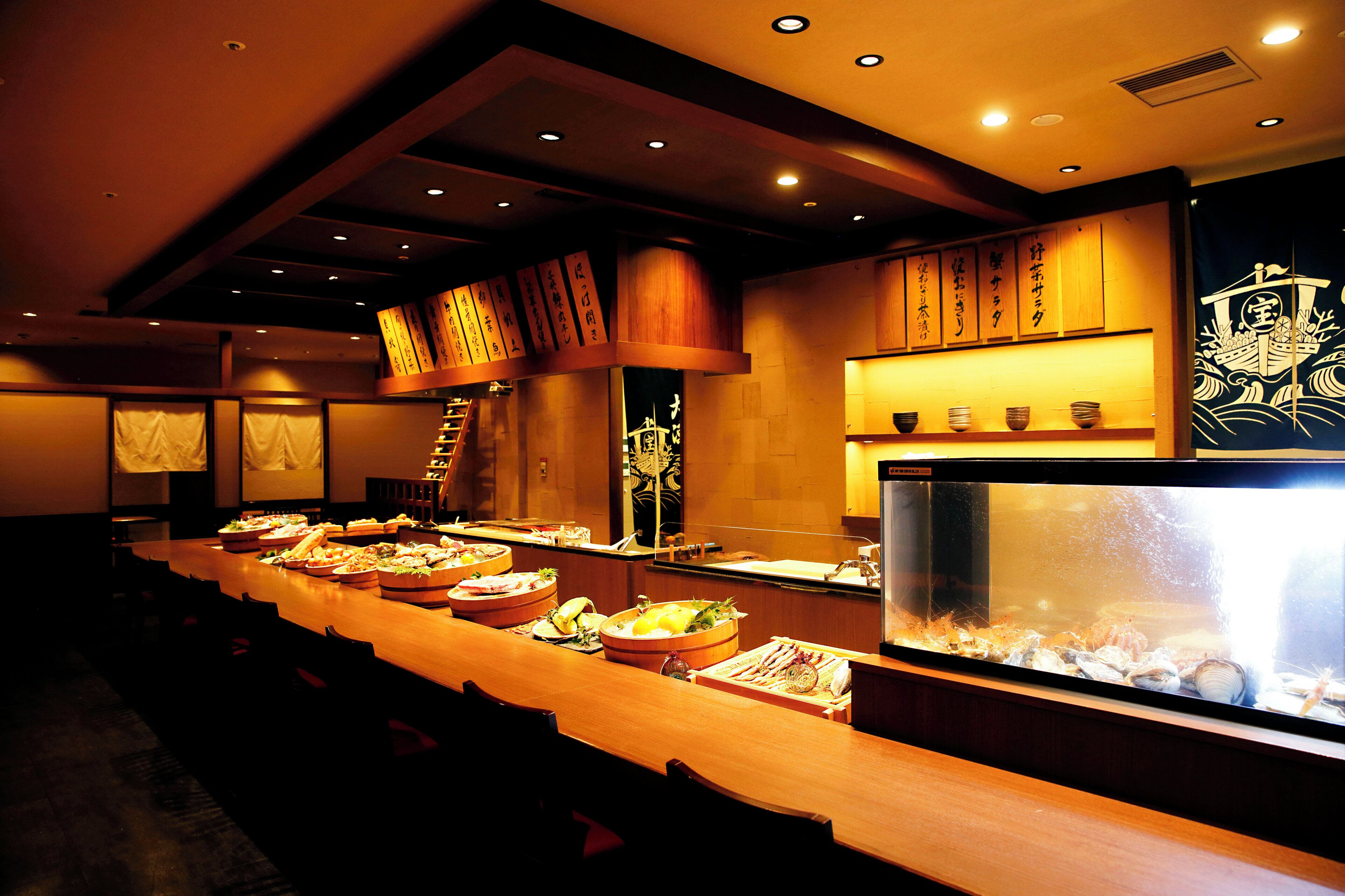 Een buffet met diverse gerechten en een groot aquarium.
