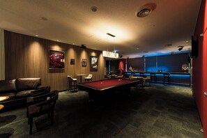 A pool table in a dimly lit room with a bar area and seating. - ANA Crowne Plaza Chitose by IHG (Chitose)