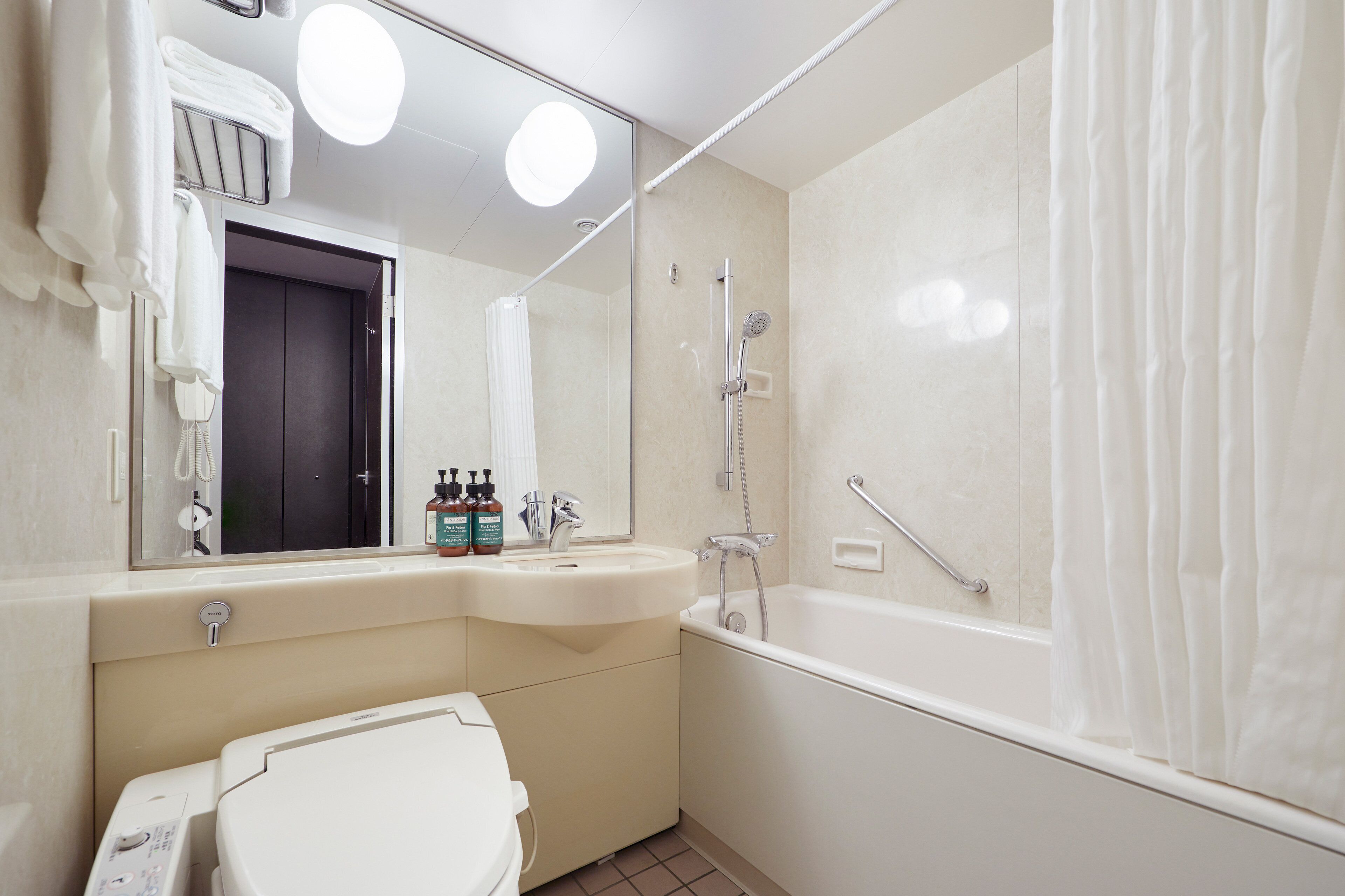 A modern bathroom with a toilet, sink, and bathtub.