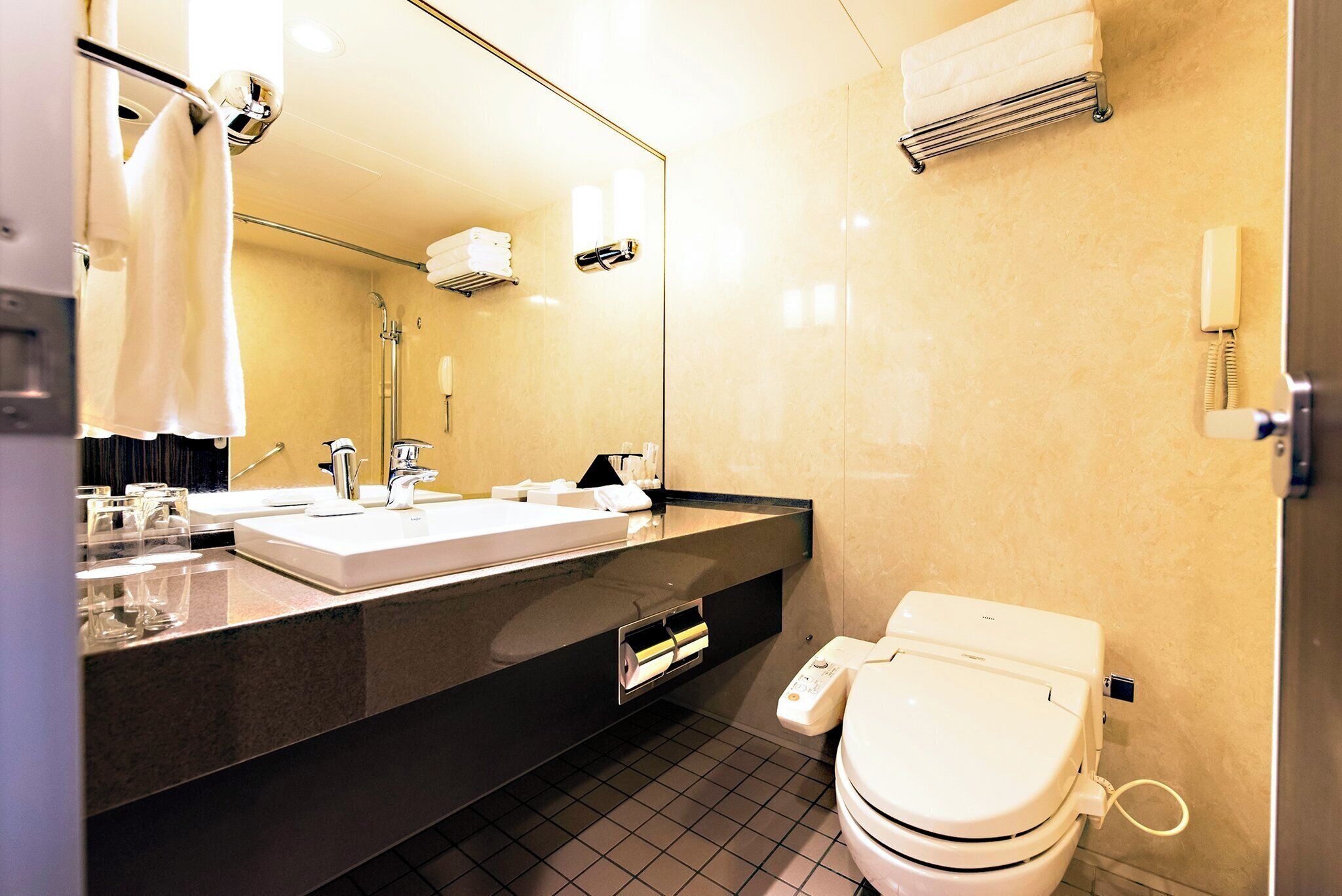 A modern bathroom with a dual sink vanity, a toilet, and a shower.