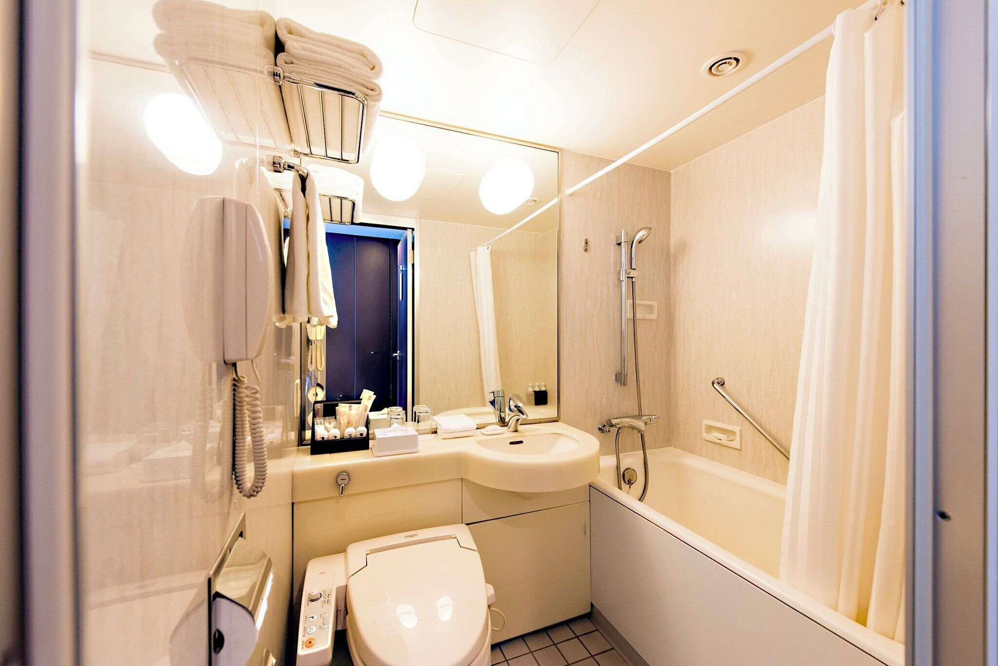 Un baño pequeño con inodoro, lavabo y ducha.