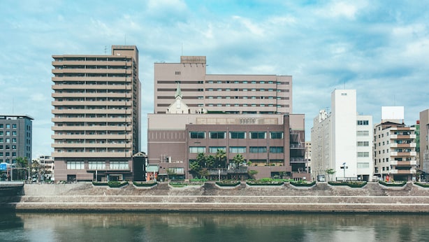 A multi-story hotel with a flat roof and a sign indicating it is the River Side Hotel. - Numazu Riverside Hotel (Numazu)