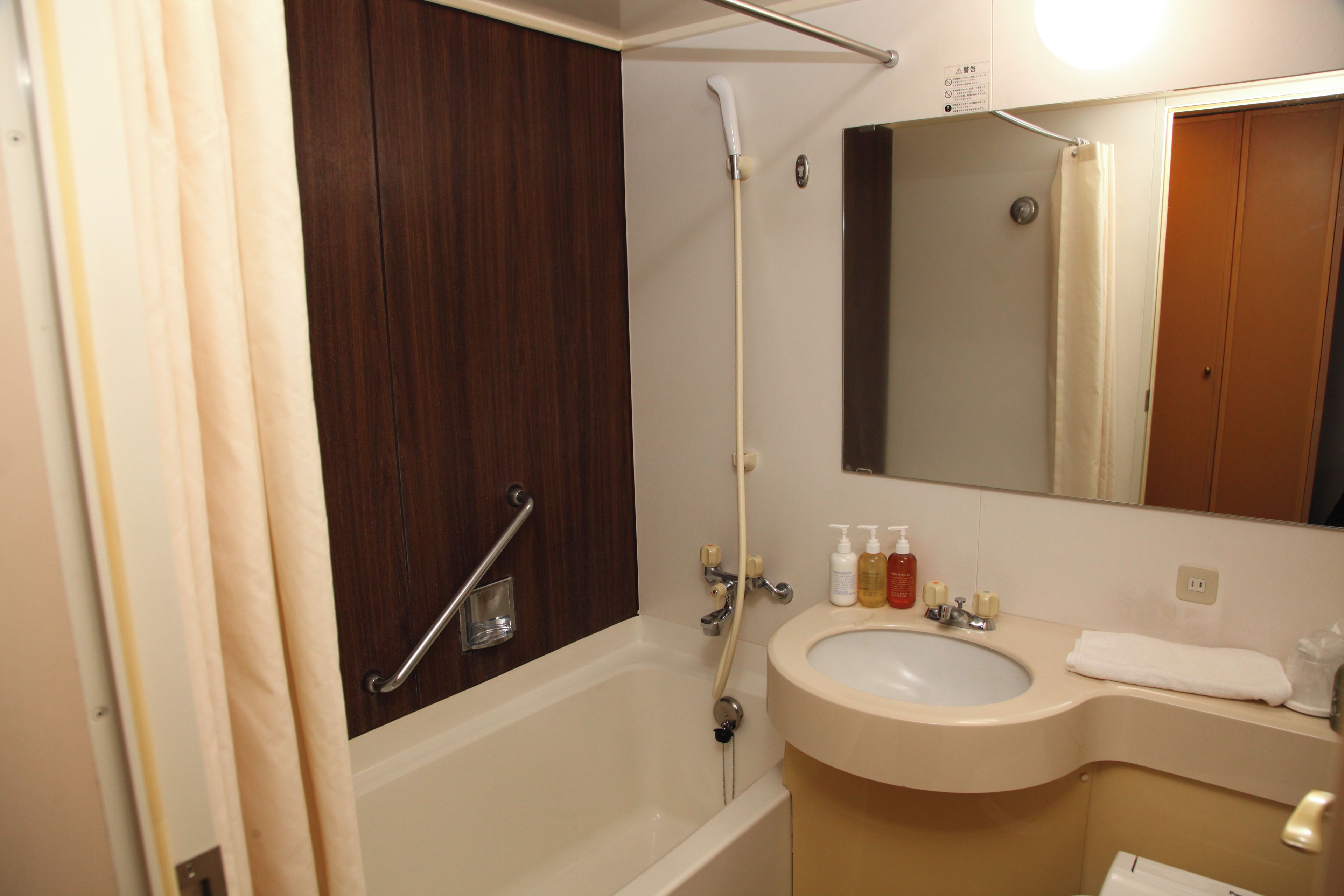 A bathroom with a bathtub, a sink, and a mirror.
