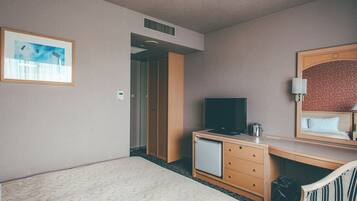 A hotel room with a bed, a desk with a television, a chair, a mirror, and a painting on the wall.