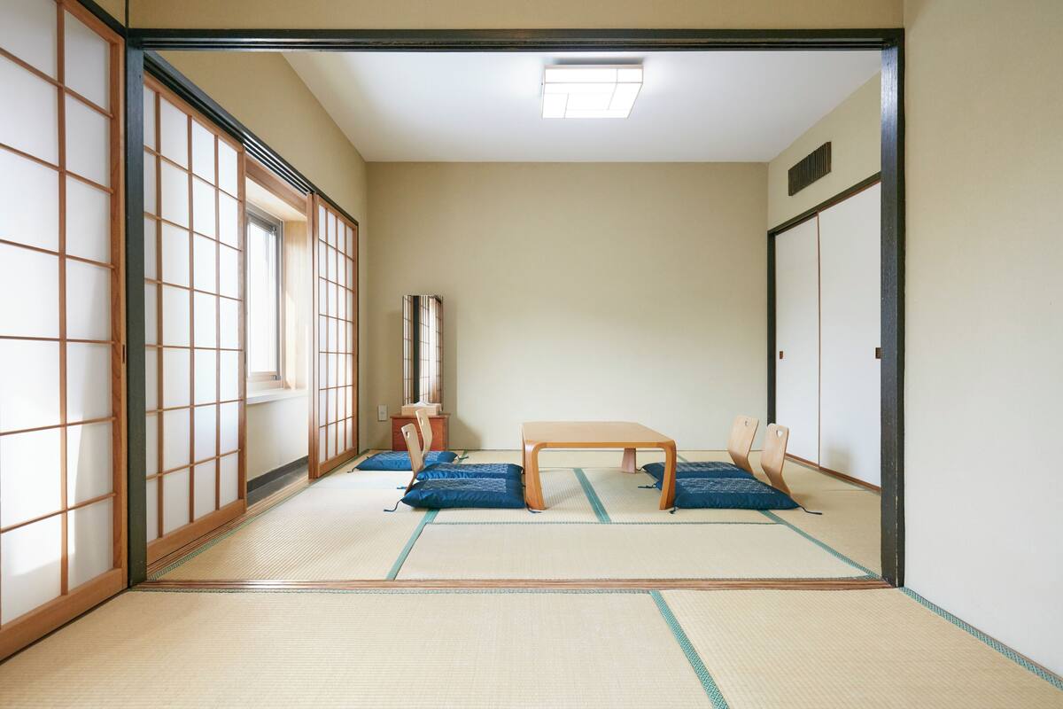 A traditional Japanese room with tatami flooring, a low wooden table, and shoji screens.