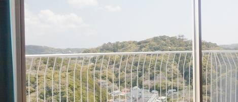 Un balcón con vistas a la ciudad y colinas.