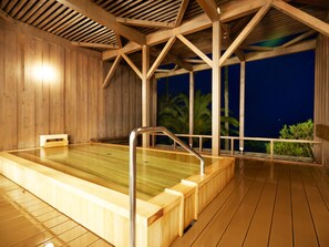 Relax in a hot tub surrounded by palm trees and a starry night sky.