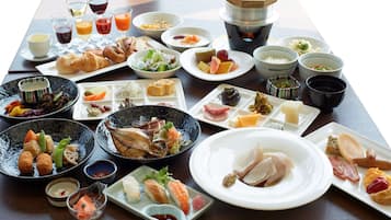 A variety of dishes and drinks on a table, including sushi, sashimi, and a teapot.