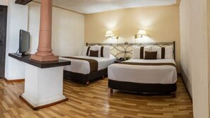 A hotel room with two beds, a TV, and a lamp. - Hotel Misión Xalapa (Xalapa)