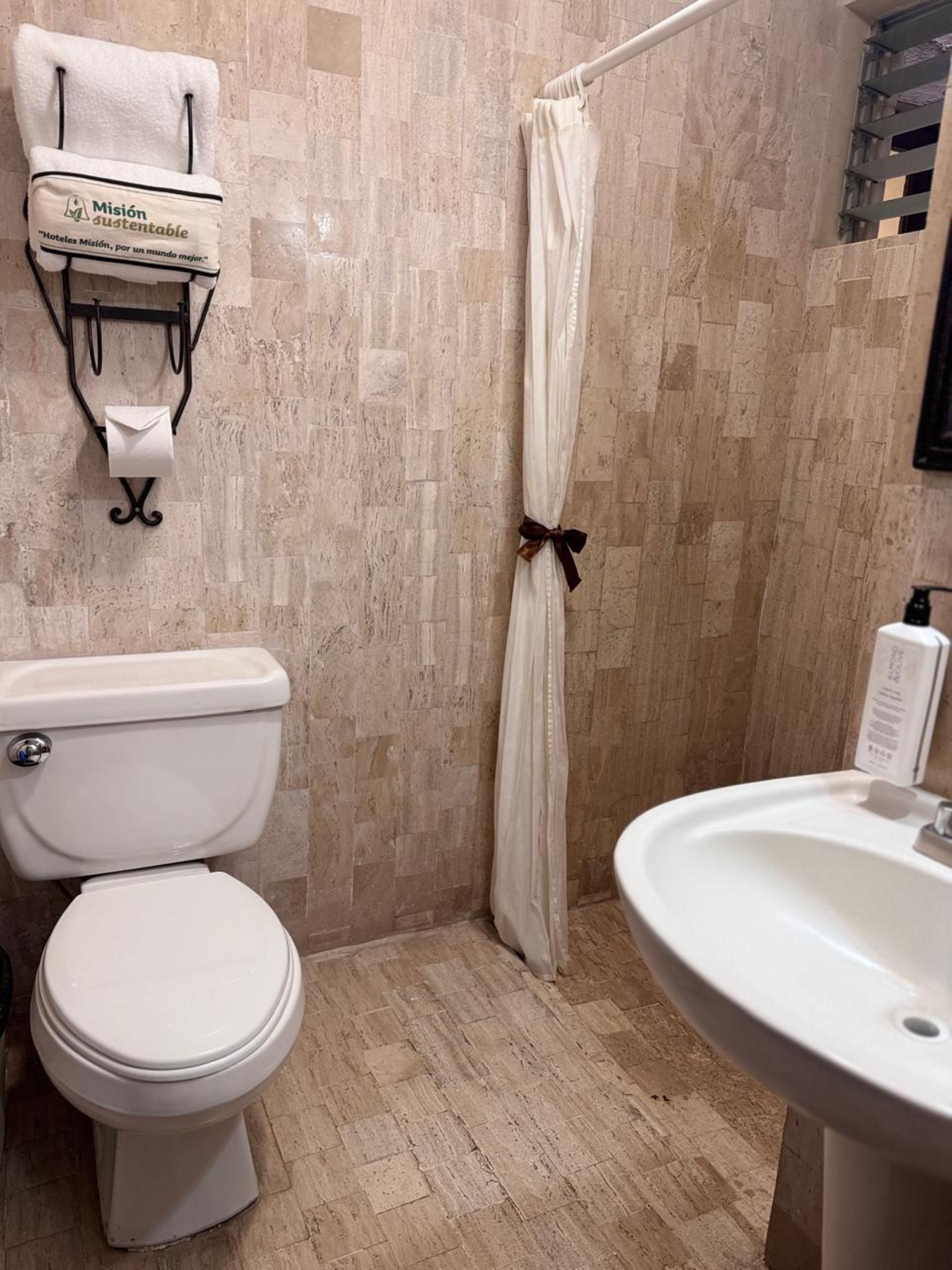 Un baño con inodoro, lavabo y cortina de ducha.