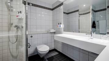 A modern bathroom with a shower, toilet, and sink.