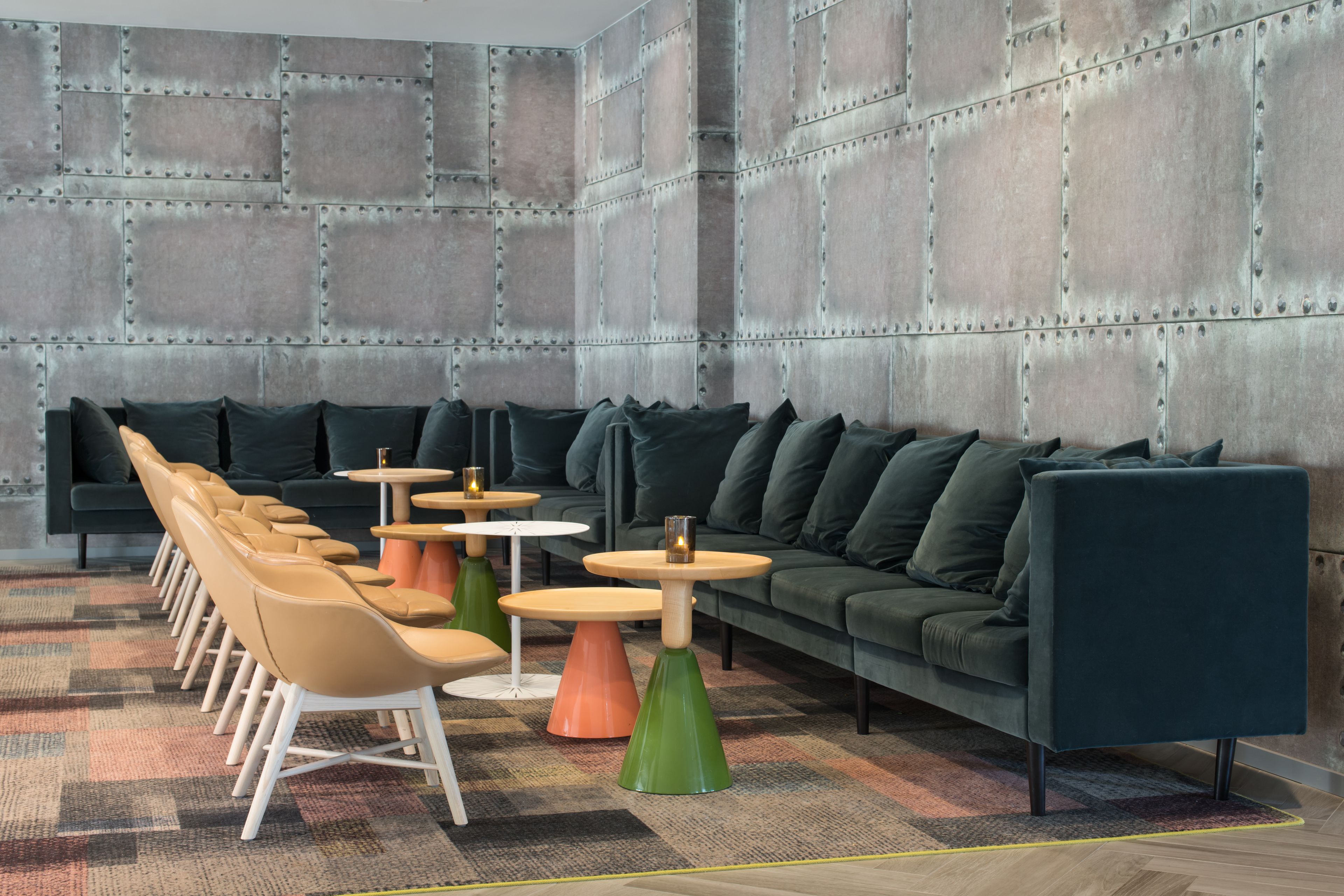 Un'area lounge moderna con divano, poltrone e tavolini.