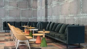 Un'area lounge moderna con divano, poltrone e tavolini.