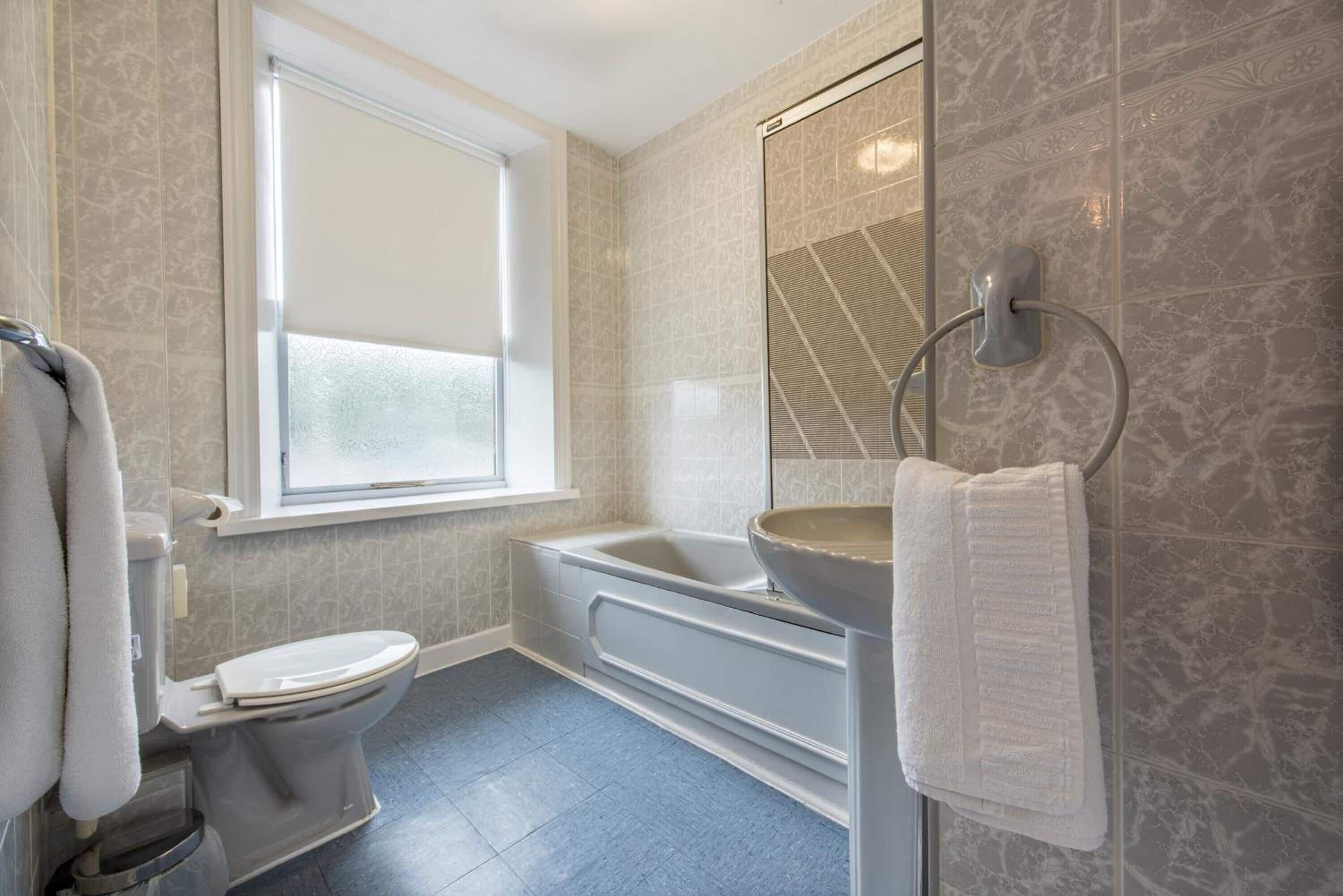 Ein modernes Badezimmer mit Toilette, Badewanne und Duschbereich.